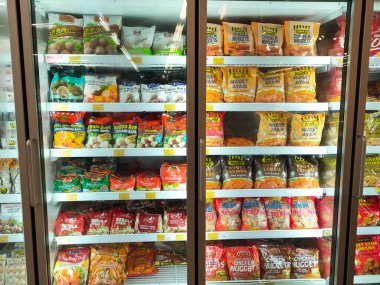 SELANGOR, MALAYSIA - 15 Nisan 2021: Dev süpermarketteki soğutucu buzdolabının içine yerleştirilmiş çeşitli markalarda tavuk nugget ticari ambalajına odaklanmış.