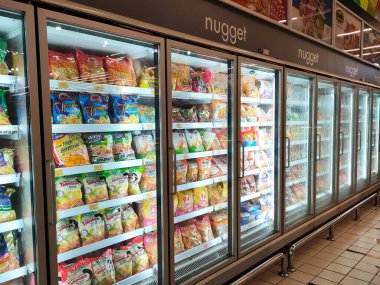 SELANGOR, MALAYSIA - 15 Nisan 2021: Dev süpermarketteki soğutucu buzdolabının içine yerleştirilmiş çeşitli markalarda tavuk nugget ticari ambalajına odaklanmış.