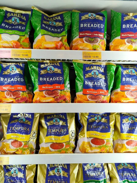 SELANGOR, MALAYSIA - 15 Nisan 2021: Dev süpermarketteki soğutucu buzdolabının içine yerleştirilmiş çeşitli markalarda tavuk nugget ticari ambalajına odaklanmış.