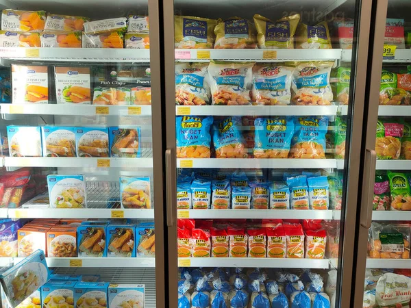 SELANGOR, MALAYSIA - 15 Nisan 2021: Dev süpermarketteki soğutucu buzdolabının içine yerleştirilmiş çeşitli markalarda tavuk nugget ticari ambalajına odaklanmış.