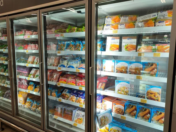 SELANGOR, MALAYSIA - 15 Nisan 2021: Dev süpermarketteki soğutucu buzdolabının içine yerleştirilmiş çeşitli markalarda tavuk nugget ticari ambalajına odaklanmış.