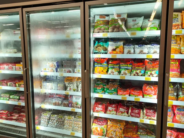 SELANGOR, MALAYSIA - 15 Nisan 2021: Dev süpermarketteki soğutucu buzdolabının içine yerleştirilmiş çeşitli markalarda tavuk nugget ticari ambalajına odaklanmış.