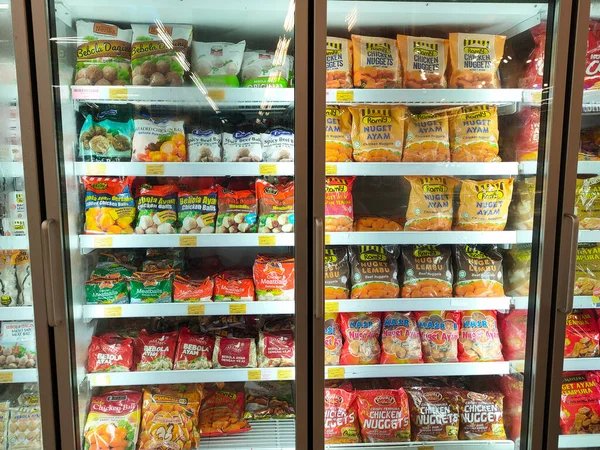 SELANGOR, MALAYSIA - 15 Nisan 2021: Dev süpermarketteki soğutucu buzdolabının içine yerleştirilmiş çeşitli markalarda tavuk nugget ticari ambalajına odaklanmış.