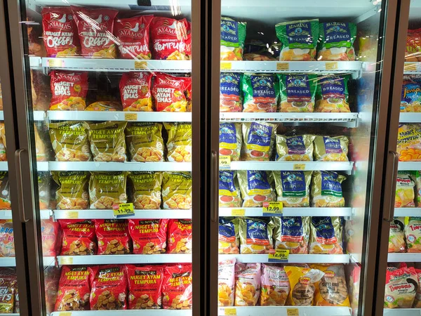 SELANGOR, MALAYSIA - 15 Nisan 2021: Dev süpermarketteki soğutucu buzdolabının içine yerleştirilmiş çeşitli markalarda tavuk nugget ticari ambalajına odaklanmış.