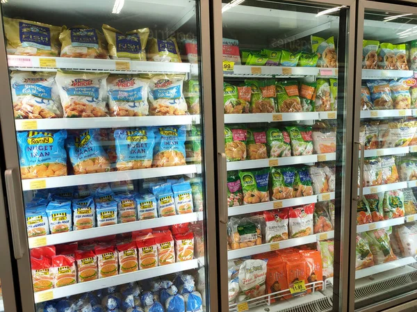 SELANGOR, MALAYSIA - 15 Nisan 2021: Dev süpermarketteki soğutucu buzdolabının içine yerleştirilmiş çeşitli markalarda tavuk nugget ticari ambalajına odaklanmış.