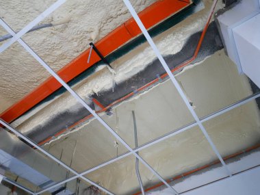 SELANGOR, MALAYSIA - 10 Mart 2022: poliüretan yalıtım köpüğü püskürtülmüş ve beton levhaların altındaki yüzeyi kaplamıştır. Binanın termal yalıtımı için bir katman görevi görür..