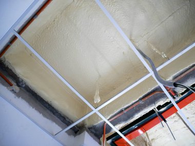 SELANGOR, MALAYSIA - 10 Mart 2022: poliüretan yalıtım köpüğü püskürtülmüş ve beton levhaların altındaki yüzeyi kaplamıştır. Binanın termal yalıtımı için bir katman görevi görür..