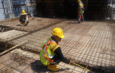 MALACCA, MALAYSIA -HAZİRAN 14, 2017: İnşaat işçileri inşaat sahasına döşeme destek çubuğu kurup üretiyorlar. Destek çubuğu ince bir kabloyla birbirine bağlanmış.. 