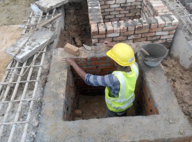JASIN, MALAYSIA - SEPTEMBER 09, 2016: İnşaat alanında inşaat halindeki tuğla duvar işçiliği. Çamur tuğlası çimento harcı kullanılarak birbirine tutturulmuş..   