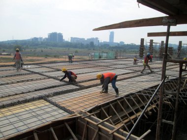 MALACCA, MALAYSIA -HAZİRAN 14, 2017: İnşaat işçileri inşaat sahasına döşeme destek çubuğu kurup üretiyorlar. Destek çubuğu ince bir kabloyla birbirine bağlanmış.. 