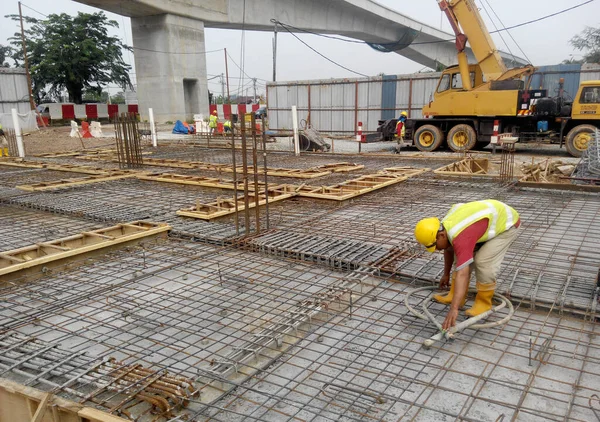 MALACCA, MALAYSIA -HAZİRAN 14, 2017: İnşaat işçileri inşaat sahasına döşeme destek çubuğu kurup üretiyorlar. Destek çubuğu ince bir kabloyla birbirine bağlanmış.. 