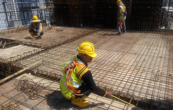 MALACCA, MALAYSIA -HAZİRAN 14, 2017: İnşaat işçileri inşaat sahasına döşeme destek çubuğu kurup üretiyorlar. Destek çubuğu ince bir kabloyla birbirine bağlanmış.. 