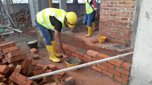 JASIN, MALAYSIA - SEPTEMBER 09, 2016: İnşaat alanında inşaat halindeki tuğla duvar işçiliği. Çamur tuğlası çimento harcı kullanılarak birbirine tutturulmuş..   