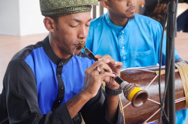 SELANGOR, MALAYSIA - 17 ARALIK 2016: Bir adam nafiri oynuyor. Nafiri sadece Malezya 'nın nobat orkestralarında bulunan bir tür trompettir..