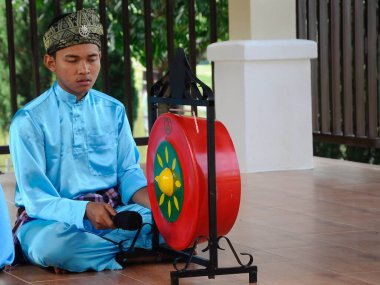 SELANGOR, MALAYSIA - 07 ARALIK 2016: Bir adam gong oynuyor. Geleneksel Malezya gongu normalde kraliyet töreninde çalınır.. 