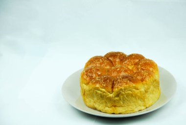 İzole edilmiş yuvarlak şekil bir somun ekmek, beyaz arka planda bir tabağın üzerindeki şeker..