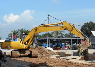 PERAK, MALAYSIA - SEPTEMBER 17, 2016: Kazı makineleri inşaatta kazı toprağı kullanılan ağır inşaat makinesidir. Kovayla çalışan uzun hidrolik kollar..  