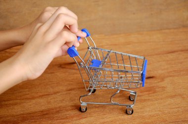 Çocuklar oyuncak alışveriş arabalarını ahşap dokuda elle itiyorlar.. 