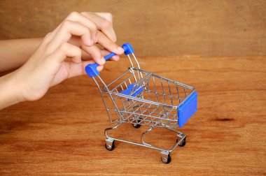 Çocuklar oyuncak alışveriş arabalarını ahşap dokuda elle itiyorlar.. 