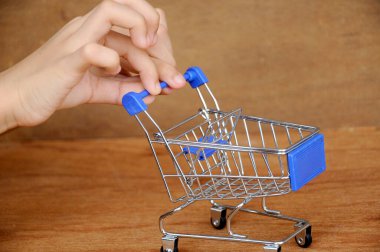 Çocuklar oyuncak alışveriş arabalarını ahşap dokuda elle itiyorlar.. 