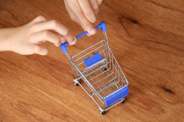 Çocuklar oyuncak alışveriş arabalarını ahşap dokuda elle itiyorlar.. 