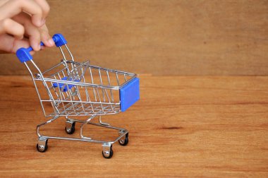 Çocuklar oyuncak alışveriş arabalarını ahşap dokuda elle itiyorlar.. 