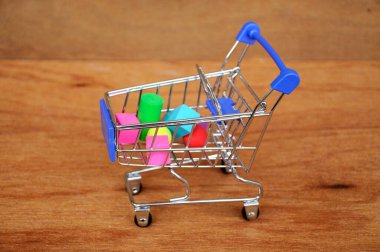 Oyuncak alışveriş vagonunun içindeki tahta desenli plastik küp ve diğer şekillerle dolu.. 