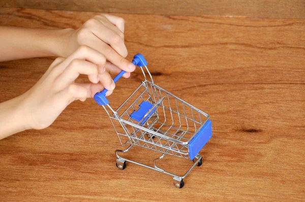 Çocuklar oyuncak alışveriş arabalarını ahşap dokuda elle itiyorlar.. 