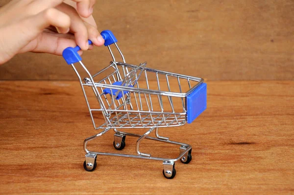 Çocuklar oyuncak alışveriş arabalarını ahşap dokuda elle itiyorlar.. 