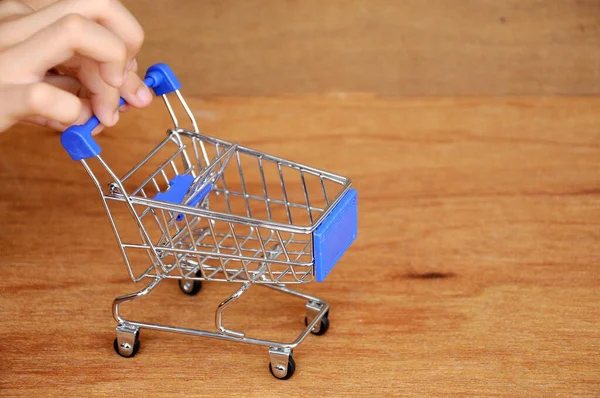 Çocuklar oyuncak alışveriş arabalarını ahşap dokuda elle itiyorlar.. 