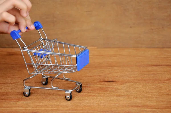 Çocuklar oyuncak alışveriş arabalarını ahşap dokuda elle itiyorlar.. 