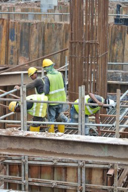SERDANG, MALAYSIA - 23 Eylül 2016: İnşaat şantiyesindeki çelik destek çubuğunun üzerinde duran güvenlik ayakkabısı giyen inşaat işçileri.  