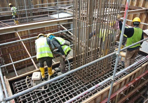 SERDANG, MALAYSIA - 23 Eylül 2016: İnşaat şantiyesindeki çelik destek çubuğunun üzerinde duran güvenlik ayakkabısı giyen inşaat işçileri.  