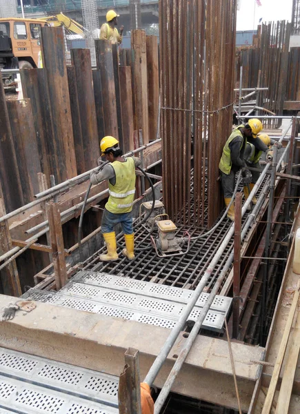 SERDANG, MALAYSIA - 23 Eylül 2016: İnşaat şantiyesindeki çelik destek çubuğunun üzerinde duran güvenlik ayakkabısı giyen inşaat işçileri.  