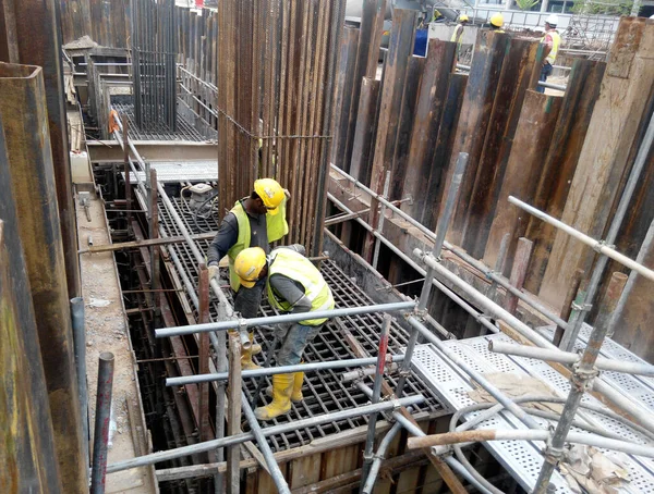 SERDANG, MALAYSIA - 23 Eylül 2016: İnşaat şantiyesindeki çelik destek çubuğunun üzerinde duran güvenlik ayakkabısı giyen inşaat işçileri.  