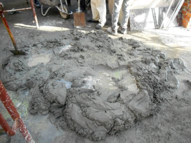 MALACCA, MALAYSIA -24 AĞUSTOS: İnşaat işçileri tuğla ve sıva işi için harç oluşturmak amacıyla çimento, kum ve suyu elle karıştırıyorlar. 