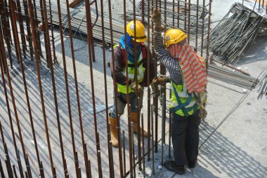 MALACCA, MALAYSIA - SEPTEMBER 28, 2016: Malacca, Malezya 'daki inşaat alanında döşeme destek barı üreten inşaat işçileri.  