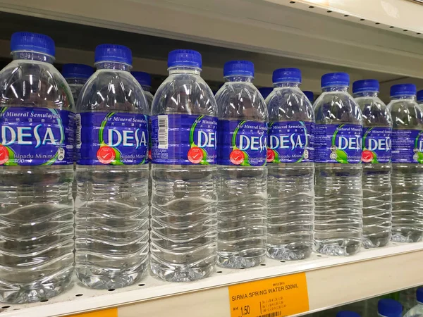KUALA LUMPUR, MALAYSIA -APRIL 3, 2022: Maden suyu paketlenir ve plastik şişelerde çeşitli markalarla etiketlenir. Süpermarketin içindeki bir rafta sergileniyor. Bir fiyat etiketi ile yerleştirilmiş