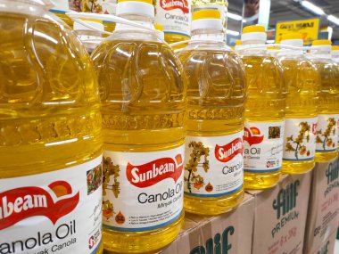 SELANGOR, MALAYSIA 7 MAYIS 2022: ticari plastik şişelerde satılık kanola yağı ve ayçiçeği yağı. Markaya göre etiketlenmiş ve fiyat etiketi var..