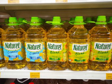 SELANGOR, MALAYSIA 7 MAYIS 2022: ticari plastik şişelerde satılık kanola yağı ve ayçiçeği yağı. Markaya göre etiketlenmiş ve fiyat etiketi var..