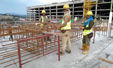 MALACCA, MALAYSIA -23 Eylül 2016: Malezya 'daki inşaat alanında çelik takviye barı üreten inşaat işçileri. Destek çubuğu ince kabloyla birbirine bağlıydı..  