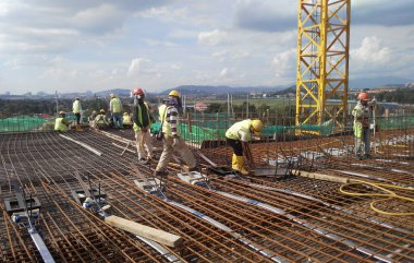 MALACCA, MALAYSIA -23 Eylül 2016: Malezya 'daki inşaat alanında çelik takviye barı üreten inşaat işçileri. Destek çubuğu ince kabloyla birbirine bağlıydı..  