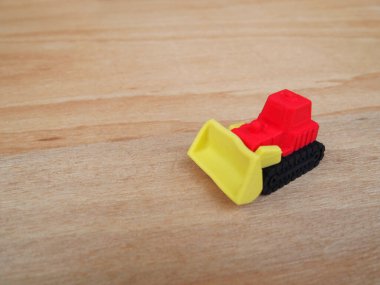 Sentetik kauçuktan yapılmış ağır makinenin minyatür modeli. Minyatür boyutta yapılmış. Çocukların ilgisini çeken renkli.