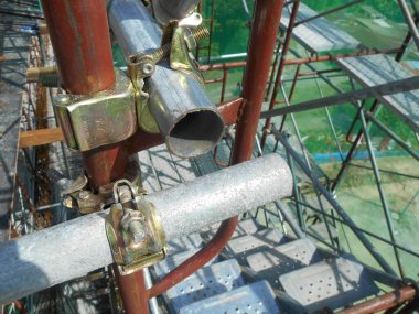 SELANGOR, MALAYSIA - 10 Temmuz 2016: İnşaat alanında yapı iskelesi bağlantısı detayı. Bağlayıcı iskeleyi ya da emniyet borusunu birbirine bağlar ya da bağlar. 