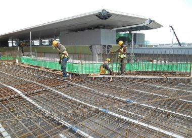 MALACCA, MALAYSIA - SEPTEMBER 24, 2016: Malacca, Malezya 'daki inşaat alanında döşeme destek barı üreten inşaat işçileri.  