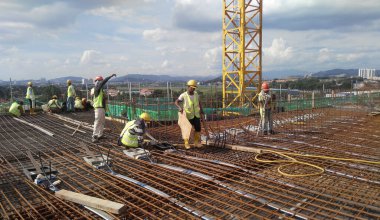 MALACCA, MALAYSIA - SEPTEMBER 24, 2016: Malacca, Malezya 'daki inşaat alanında döşeme destek barı üreten inşaat işçileri.  