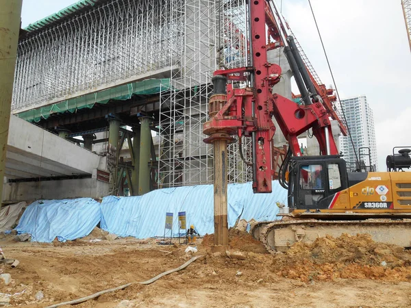 KUALA LUMPUR, MALAYSIA - 30 Mart 2022: İnşaat alanında kazık teçhizat makinesi. Bu makine vakıf inşaatı için hurda yığını sürüyordu. Yetenekli işçiler tarafından işletiliyor.. 