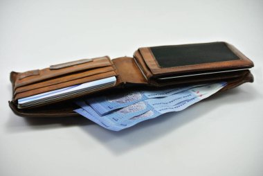 JOHOR, MALAYSIA - MAYIS 02, 2016: RM1 notları ve beyaz arkaplanda izole edilmiş eski bir cüzdan
