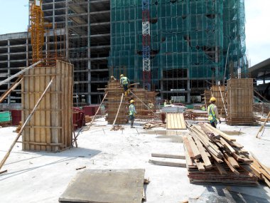 MALACCA, MALAYSIA - 25 Mart 2016: Malezya 'nın Malacca kentindeki inşaat alanında sütun kerestesi üreten inşaat işçileri. 