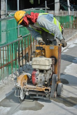 PERAK, MALAYSIA - 29 Mart 2016: İnşaat işçileri inşaat alanında testereyle beton levha veya asfalt kesiyor. 